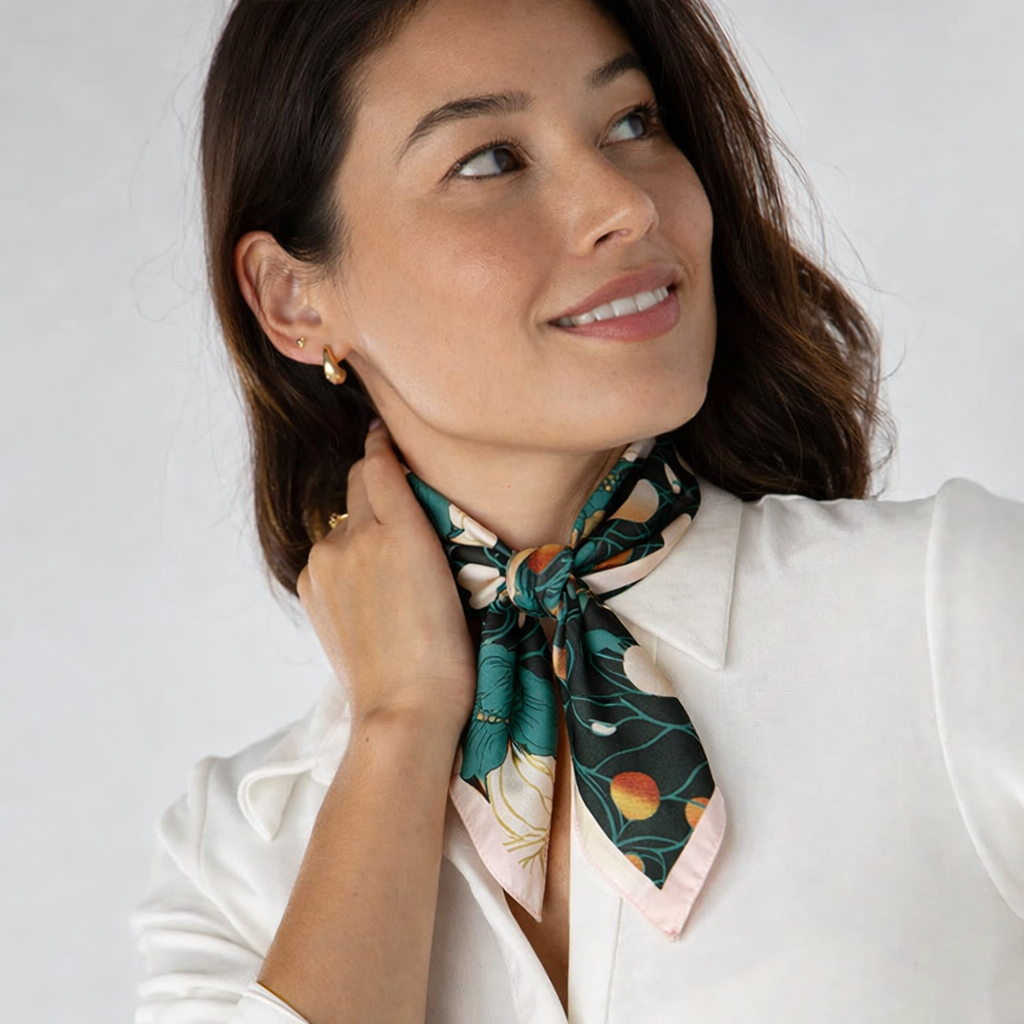 Woman wearing a floral scarf around her neck against a plain background